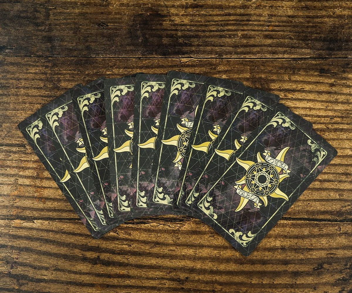 Tarot cards spread across a wooden table.
